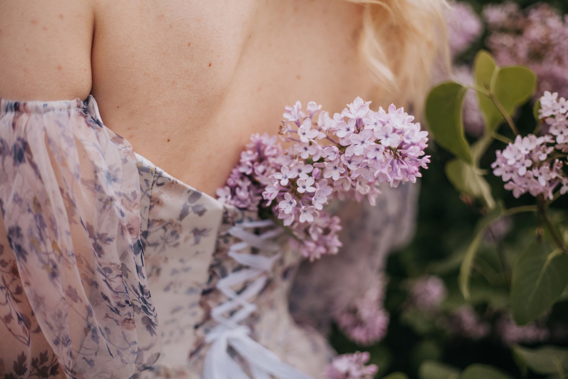 Back view of a woman in a floral dress with lilac flowers, symbolizing spring beauty.