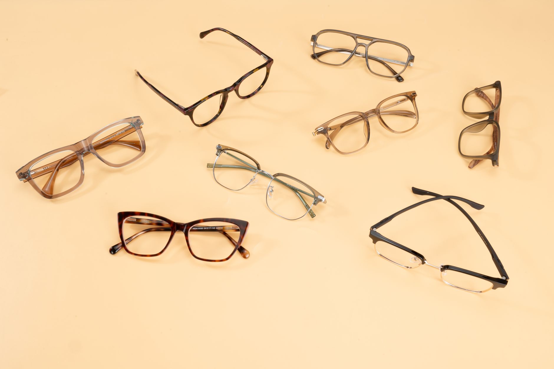 A stylish collection of eyeglasses showcased on a beige background, capturing modern fashion trends.