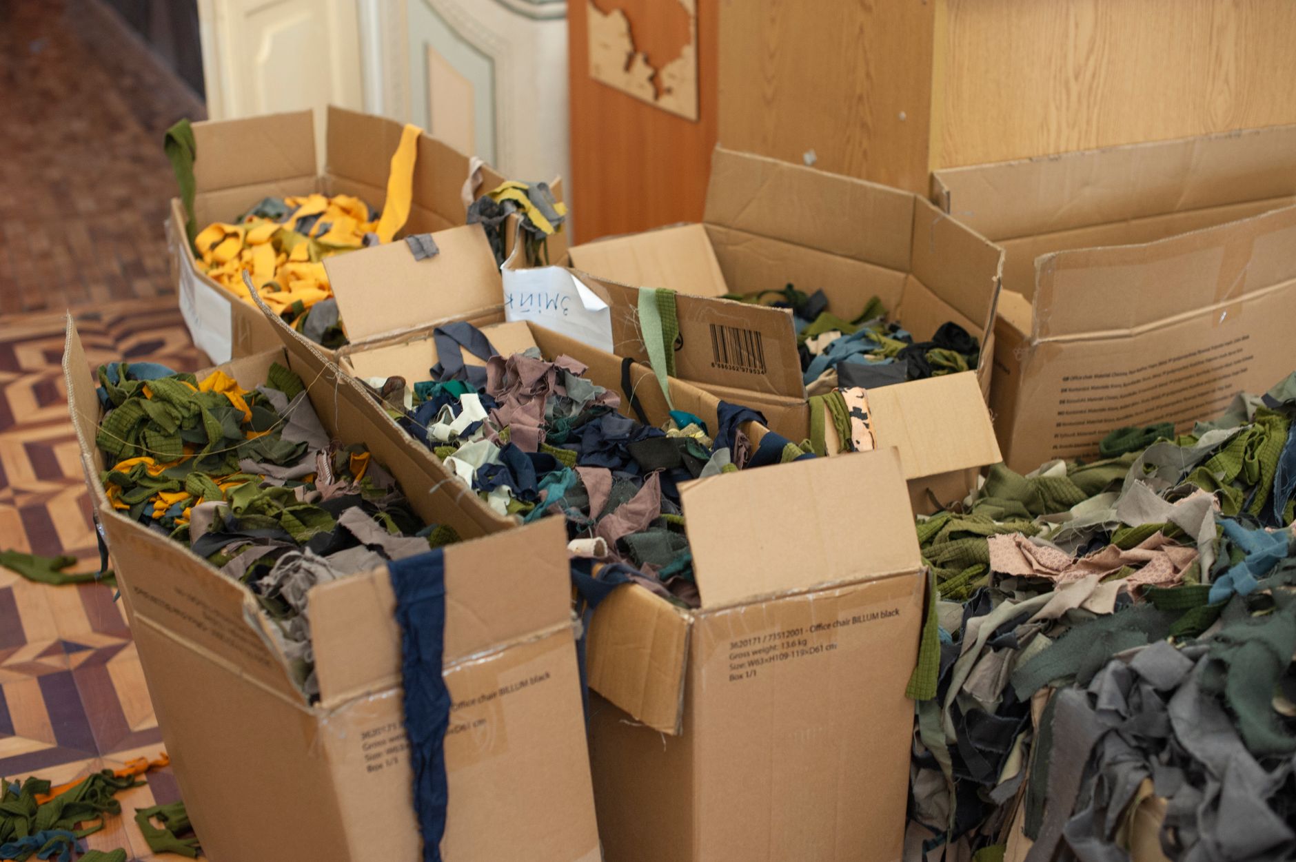 Cardboard boxes containing colorful fabric scraps for recycling in Lviv, Ukraine.