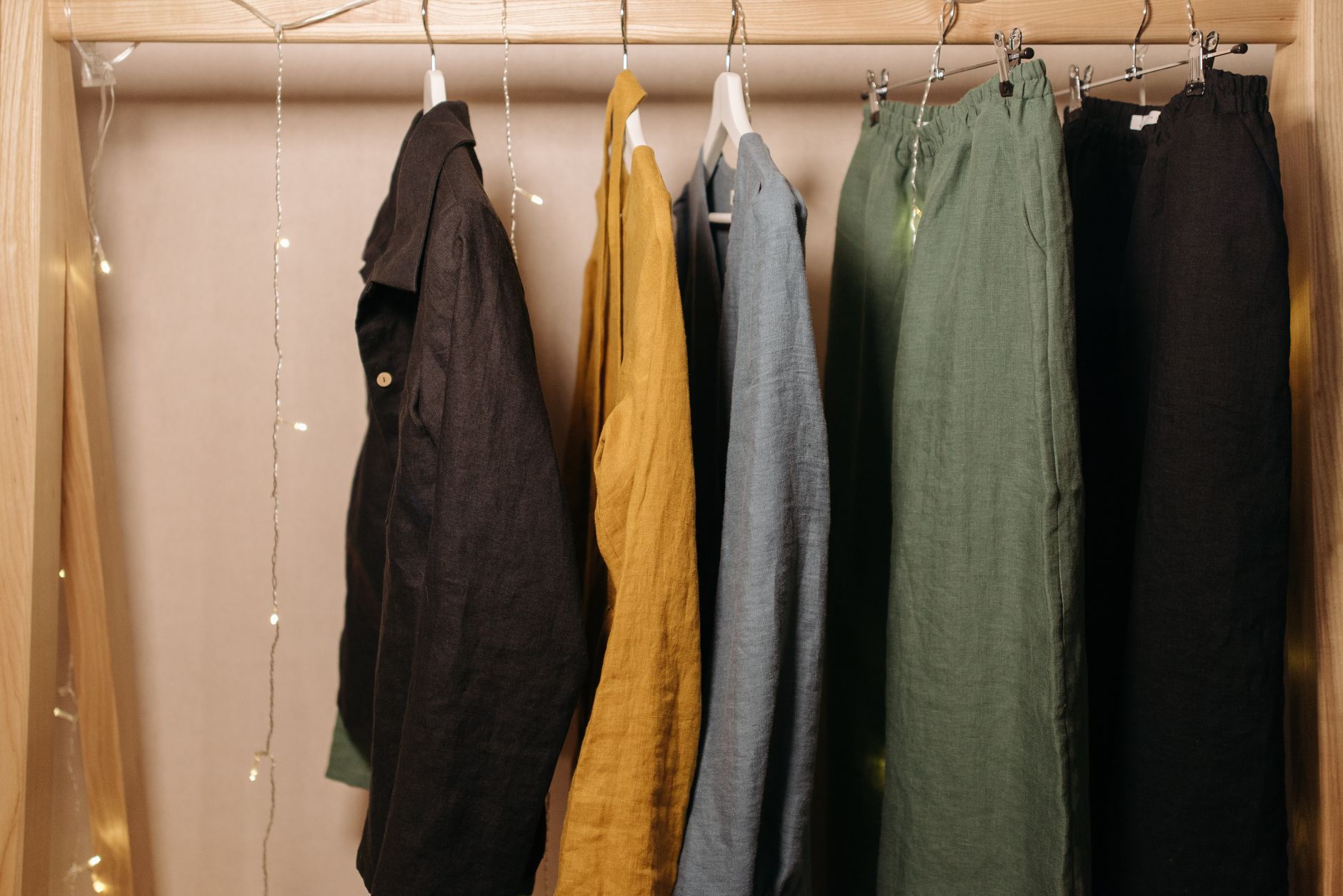 A vibrant display of linen clothes on hangers in a cozy boutique setting.