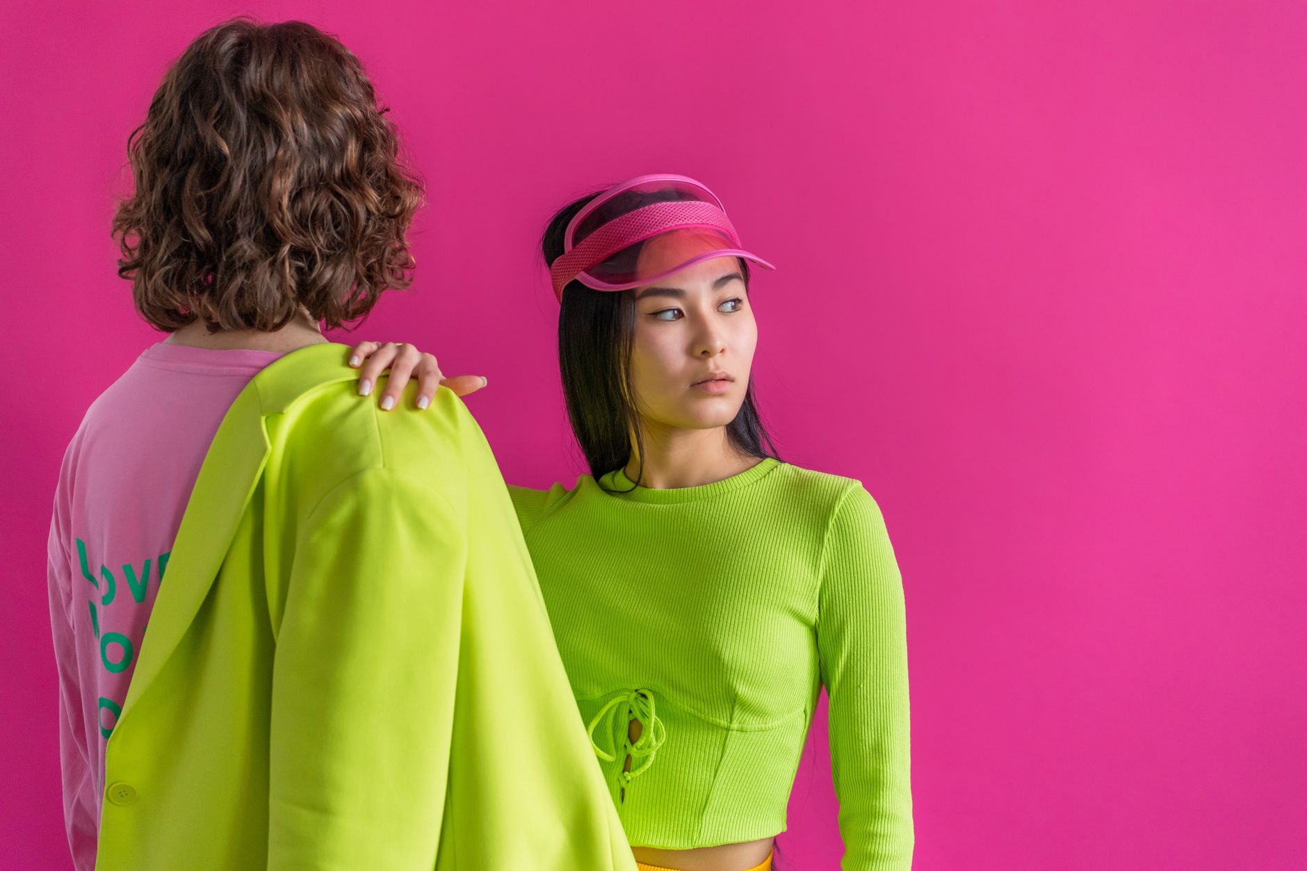 A striking studio portrait showcasing vibrant fashion with neon green and pink attire.