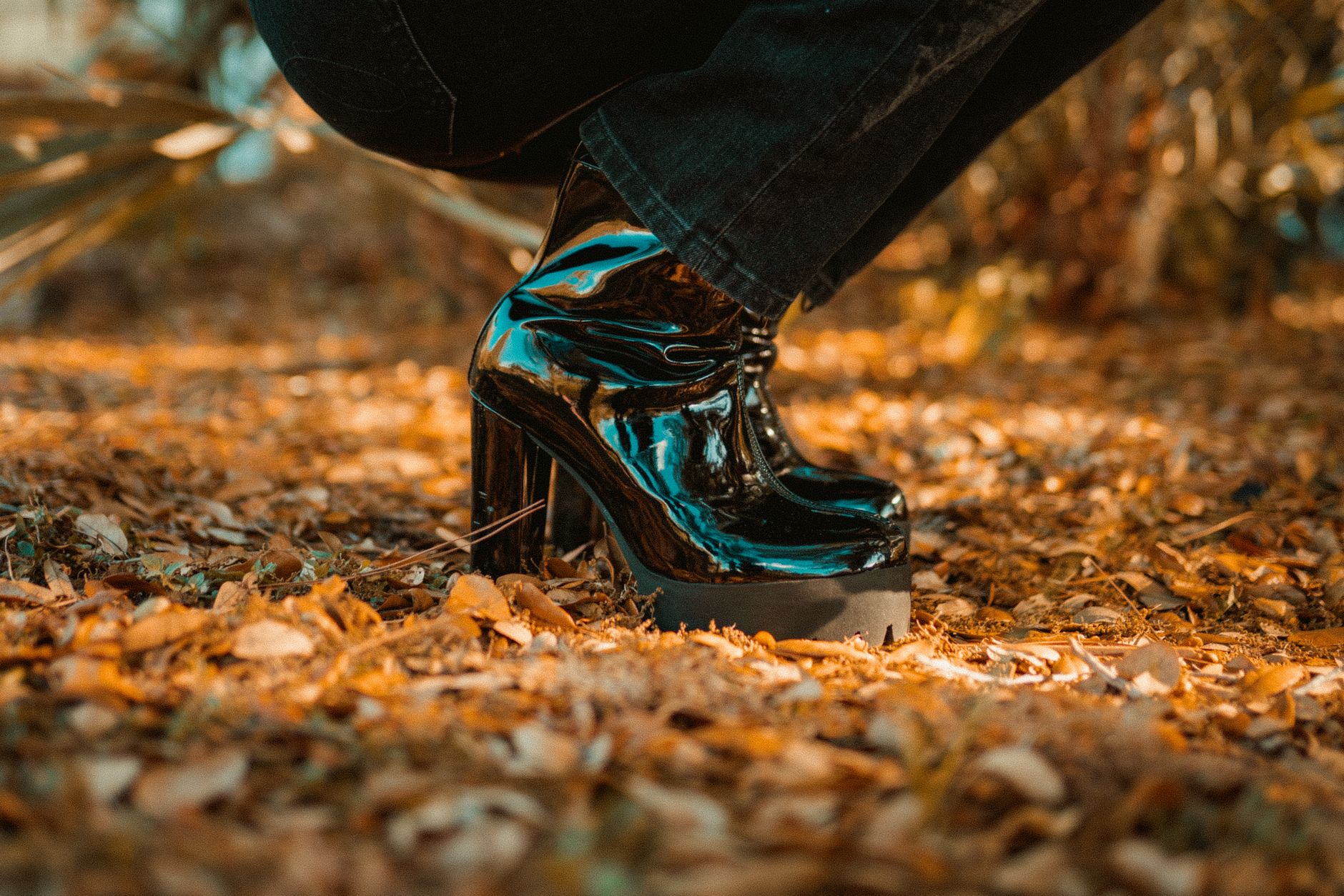 Close-up of shiny black platform boots in autumn leaves in Winter Park, Florida.