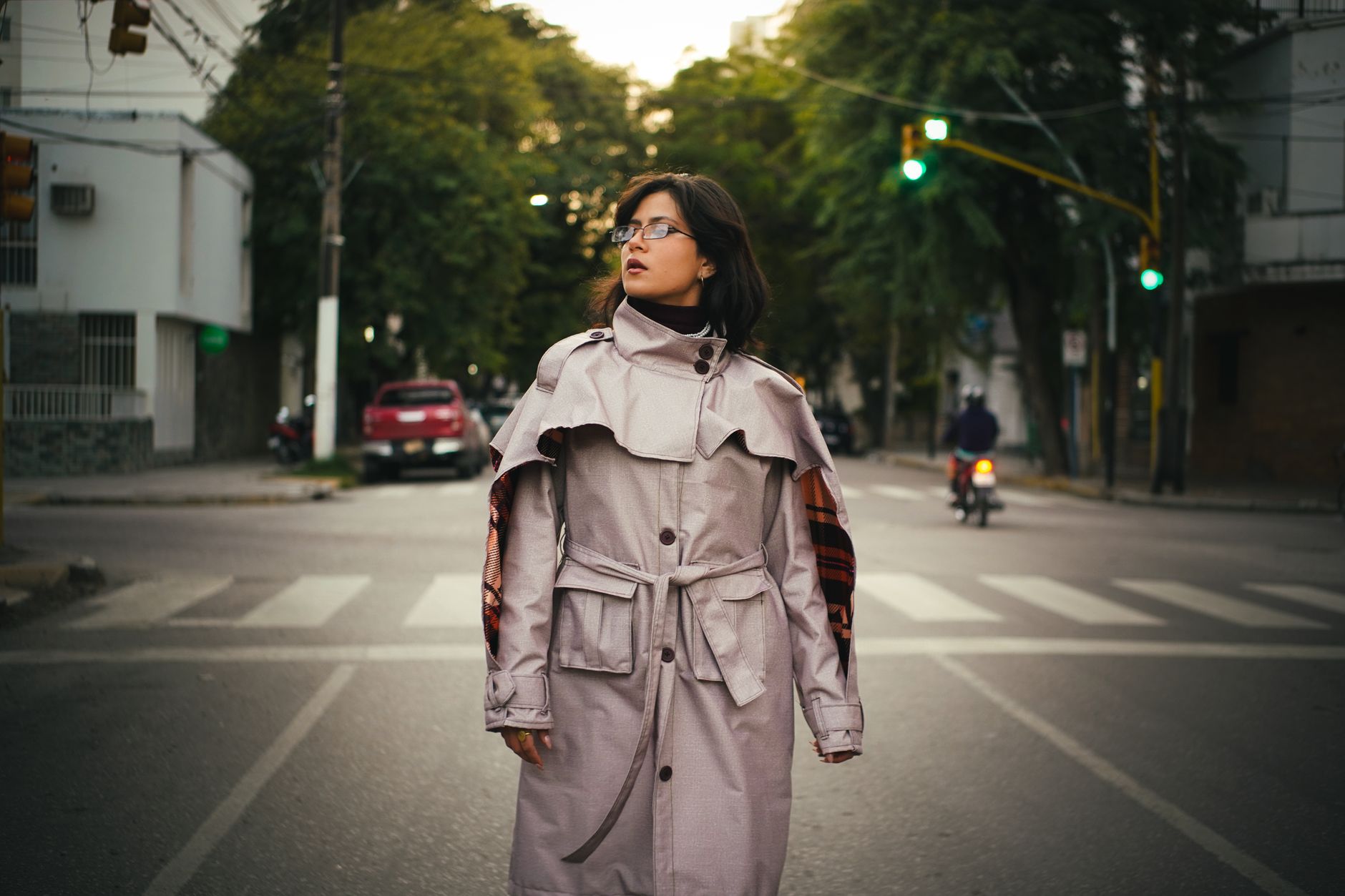 Fashionable woman in a trench coat on a city street, embodying urban style.