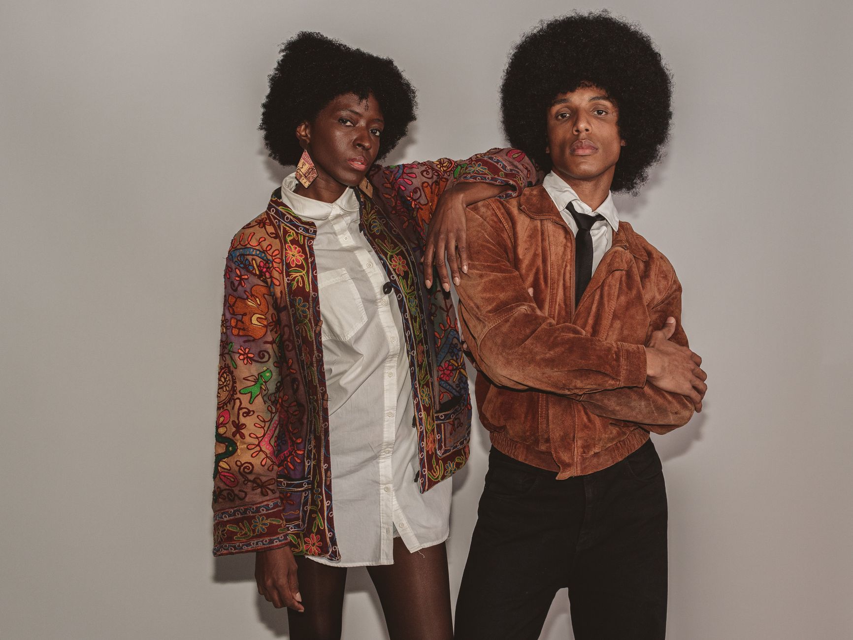 Vintage inspired portrait of two stylish individuals showcasing retro fashion with confidence.